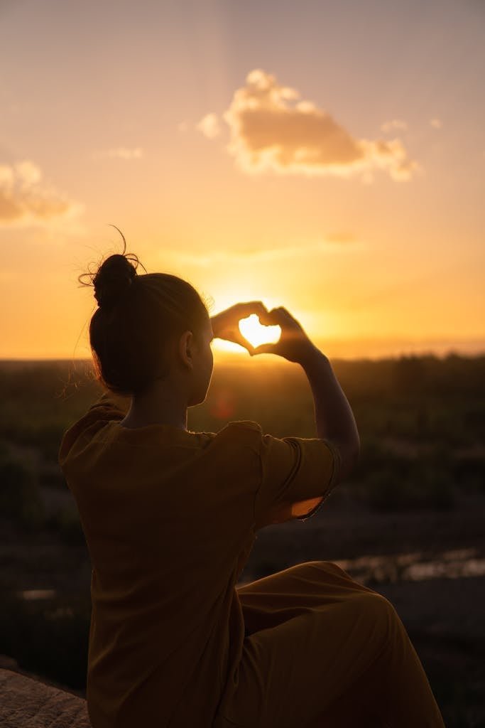 Woman Sitting While Showing Heart Sign Hands