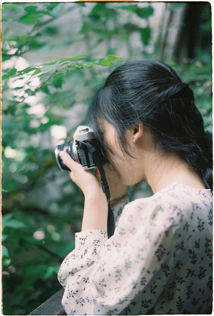 Woman Taking Picture with Retro Camera in Nature